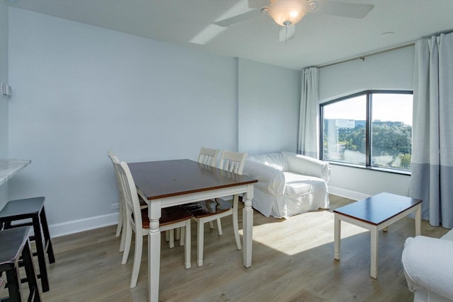 dining area with ceiling fan and hardwood / wood-style flooring