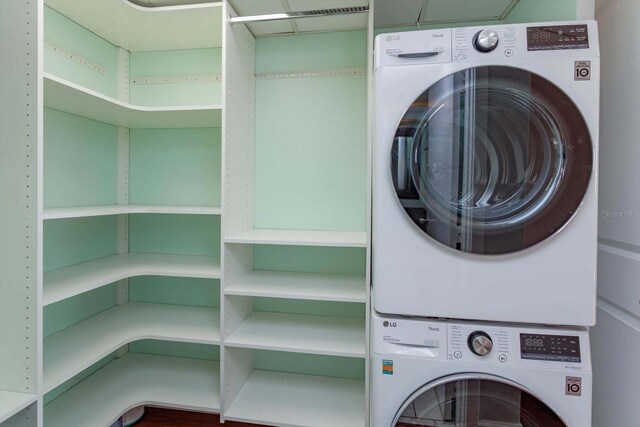 laundry area with stacked washing maching and dryer