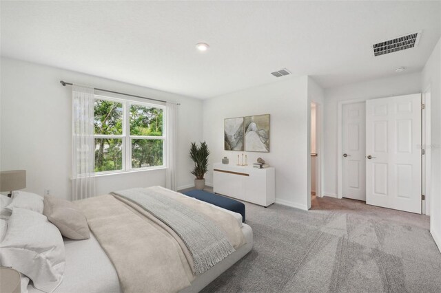 bedroom with visible vents, light carpet, and baseboards