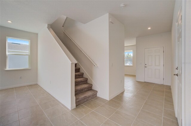 stairs featuring tile patterned flooring, baseboards, and recessed lighting