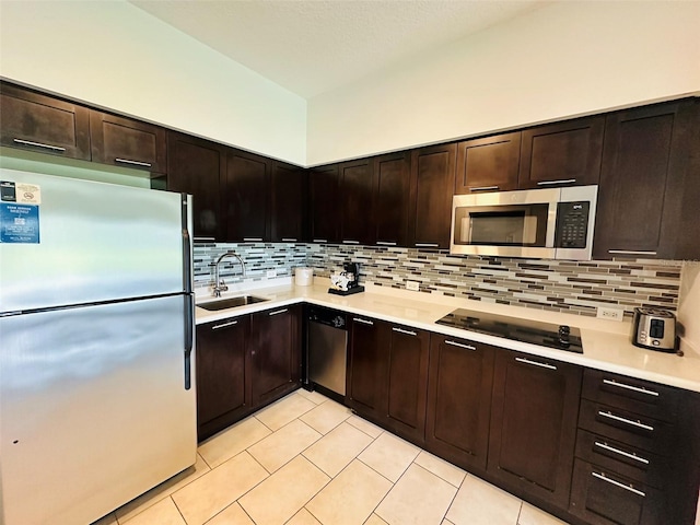 kitchen featuring appliances with stainless steel finishes, light tile patterned floors, sink, and backsplash