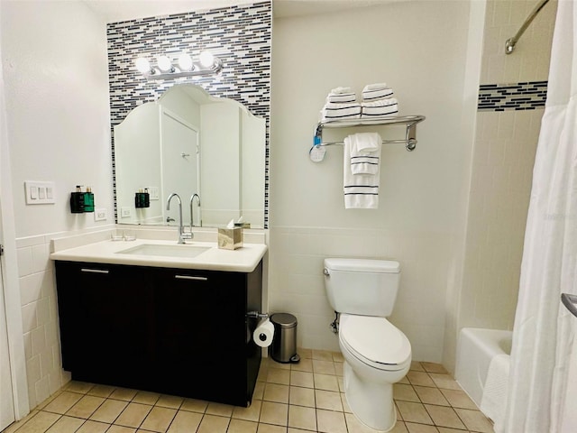 full bathroom featuring shower / tub combo with curtain, tile walls, toilet, wainscoting, and tile patterned flooring