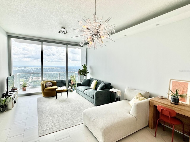 tiled living room with expansive windows, a textured ceiling, a water view, and a chandelier