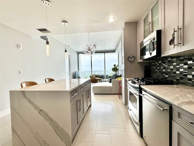 kitchen featuring dishwasher, decorative backsplash, an inviting chandelier, stove, and gray cabinets