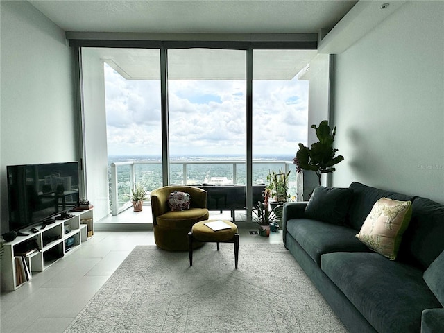 living room featuring expansive windows, light tile patterned floors, and a water view