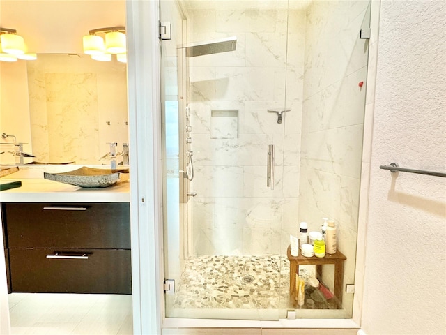 bathroom featuring tile patterned floors, an enclosed shower, and vanity