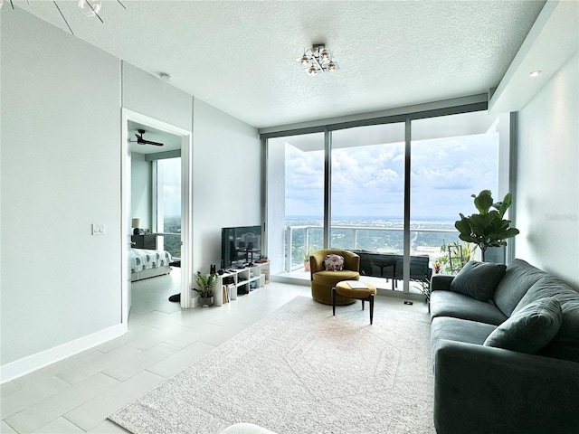 living room featuring light tile patterned floors, floor to ceiling windows, a textured ceiling, and ceiling fan