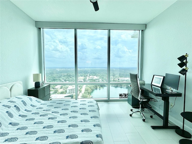 bedroom with expansive windows, ceiling fan, and light hardwood / wood-style floors