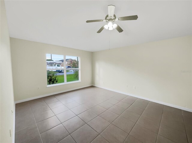 spare room with ceiling fan and tile patterned floors