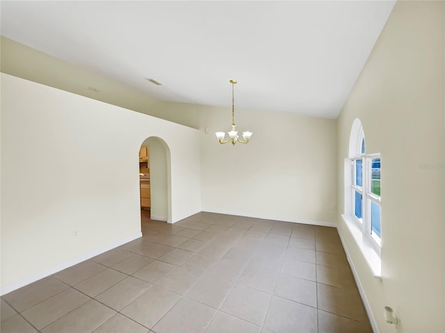 spare room with light tile patterned flooring, high vaulted ceiling, and an inviting chandelier