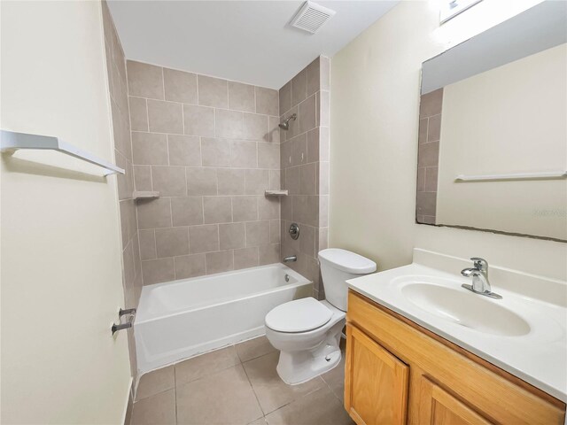 full bathroom with tile patterned flooring, tiled shower / bath, vanity, and toilet