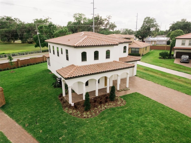 mediterranean / spanish home with a garage and a front lawn