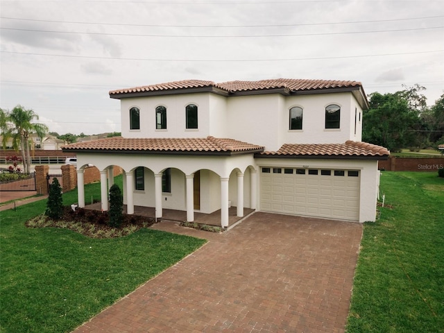 mediterranean / spanish house featuring a garage and a front yard