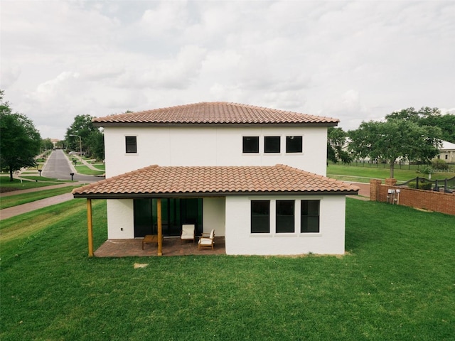 rear view of house with a patio and a lawn