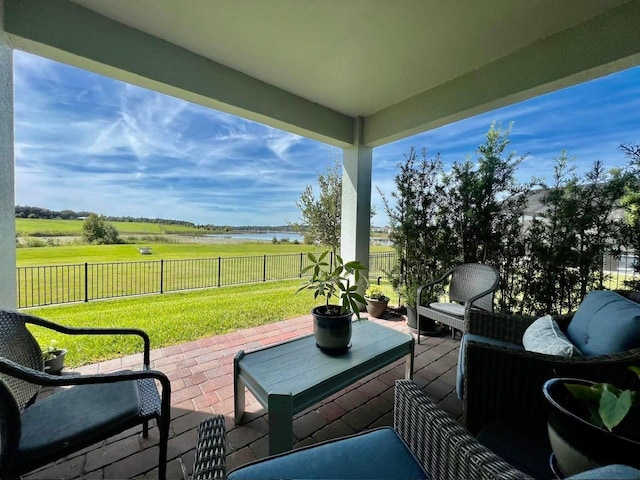 view of patio with a water view and fence