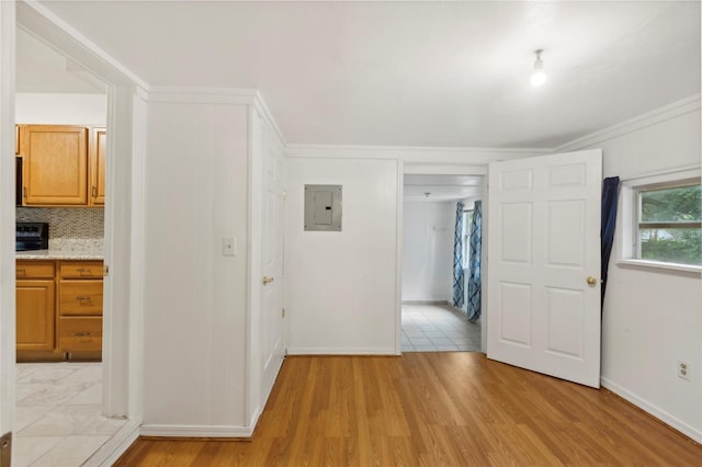 interior space with light tile patterned flooring, ornamental molding, and electric panel