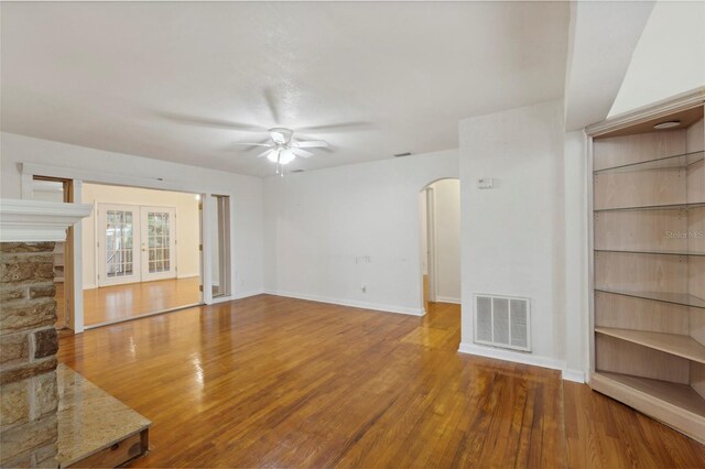 unfurnished living room featuring a fireplace, ceiling fan, and hardwood / wood-style flooring