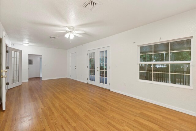 empty room featuring ceiling fan, french doors, and light hardwood / wood-style flooring