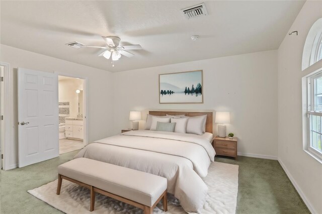 carpeted bedroom with ceiling fan and ensuite bathroom