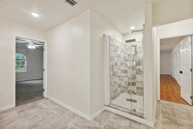 bathroom featuring tile patterned floors, a shower with door, and ceiling fan