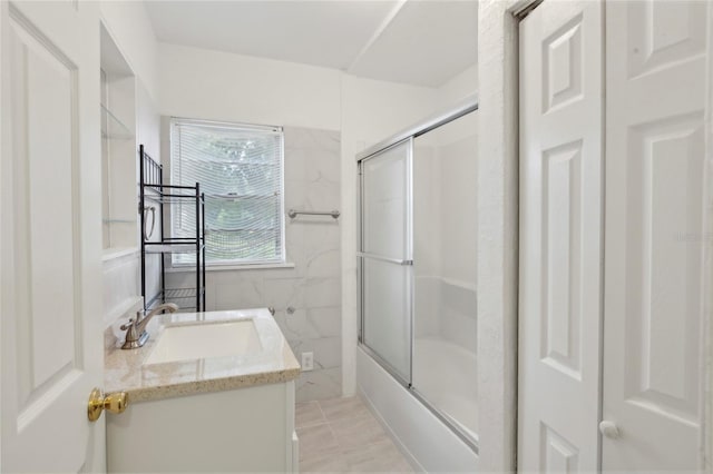 bathroom featuring tile patterned floors, tile walls, vanity, and enclosed tub / shower combo