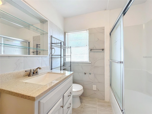 full bathroom featuring enclosed tub / shower combo, toilet, tile patterned flooring, vanity, and tile walls