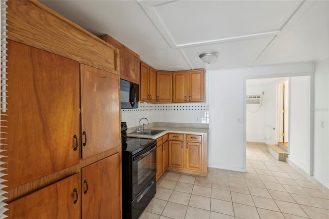 kitchen with sink, decorative backsplash, light tile patterned floors, black appliances, and a wall unit AC