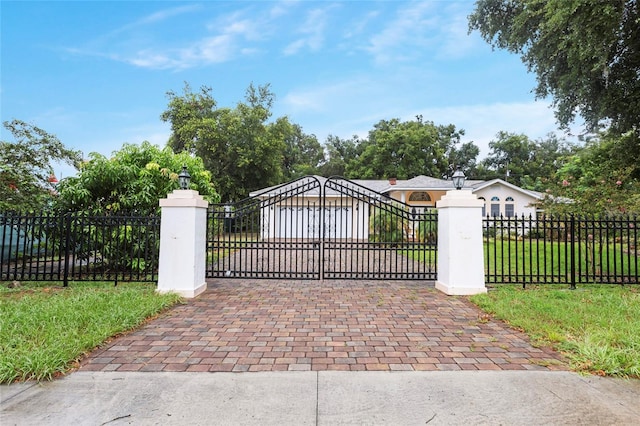 view of gate featuring a garage and a lawn