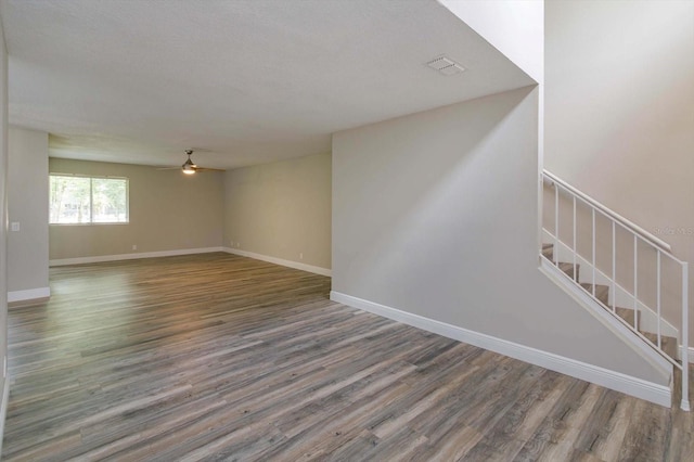 unfurnished living room featuring ceiling fan and hardwood / wood-style flooring