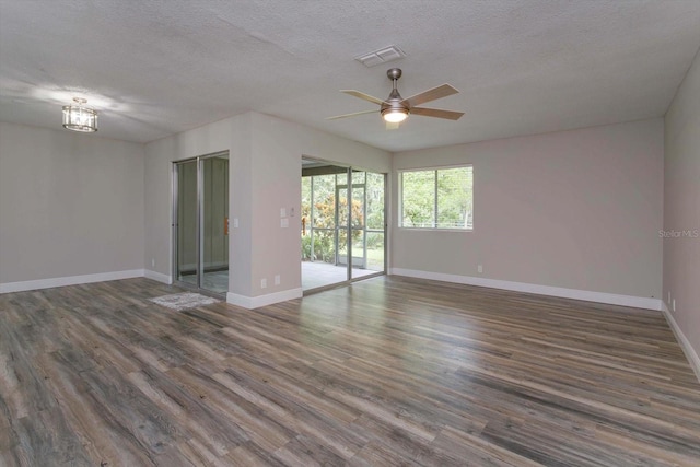 unfurnished room with a textured ceiling, ceiling fan, and dark hardwood / wood-style flooring