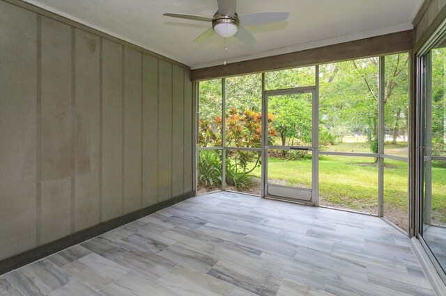 unfurnished sunroom with ceiling fan and a healthy amount of sunlight