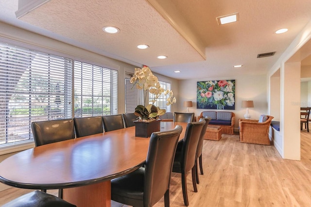 dining area with wood-type flooring and a textured ceiling