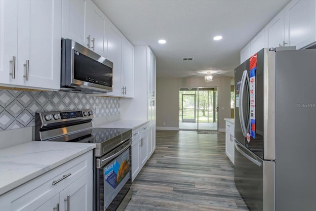 kitchen featuring light wood-type flooring, light stone countertops, decorative backsplash, appliances with stainless steel finishes, and white cabinets