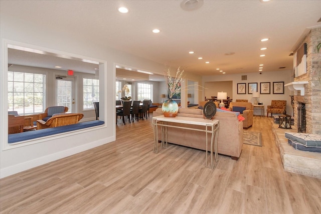 living room featuring a stone fireplace and light hardwood / wood-style floors