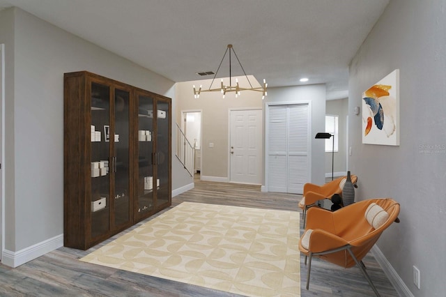 entryway featuring hardwood / wood-style flooring and a notable chandelier