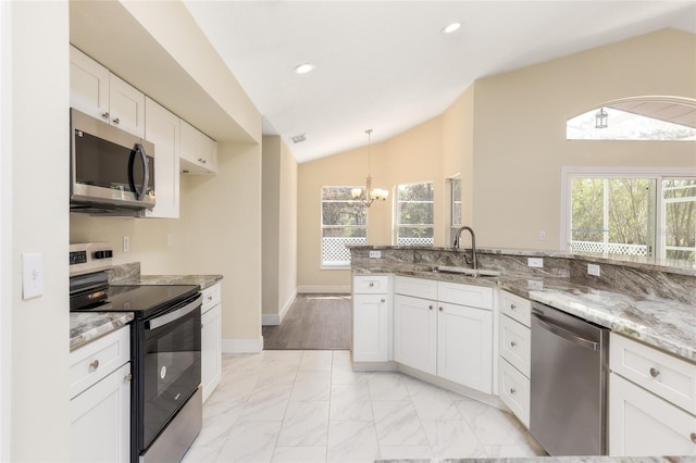 kitchen with light tile patterned flooring, sink, appliances with stainless steel finishes, light stone counters, and lofted ceiling