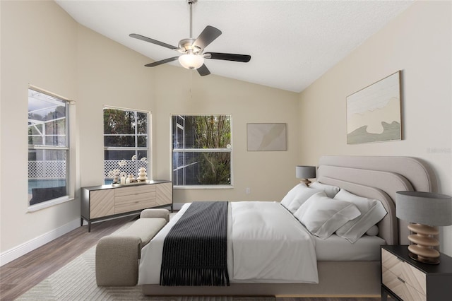 bedroom featuring ceiling fan, dark wood-type flooring, multiple windows, and lofted ceiling