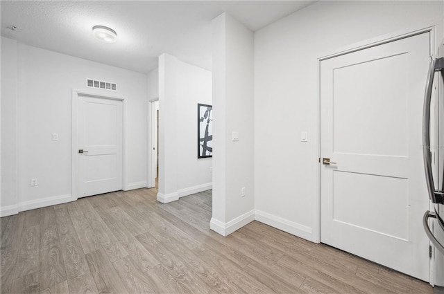 interior space with visible vents, baseboards, and light wood finished floors
