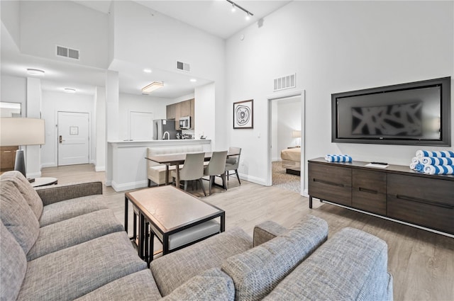 living room with light wood finished floors and visible vents