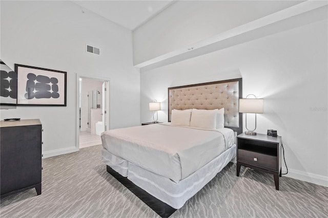 bedroom featuring visible vents, baseboards, carpet, and a towering ceiling