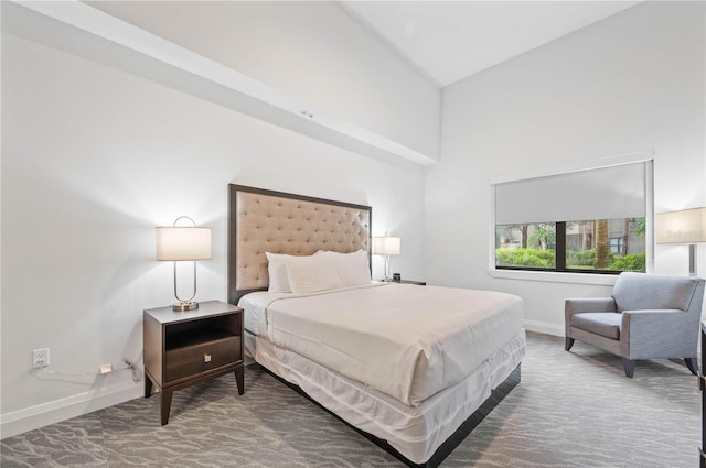 bedroom featuring baseboards, carpet floors, and high vaulted ceiling