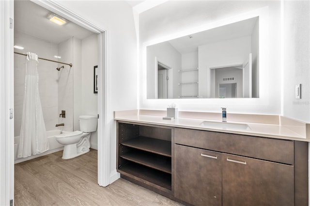 bathroom with vanity, wood finished floors, visible vents, shower / bath combo, and toilet