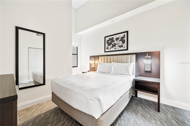 bedroom with baseboards and a towering ceiling