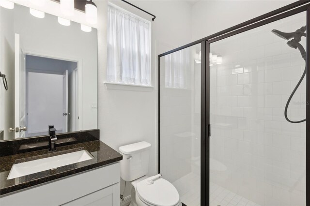 bathroom featuring walk in shower, vanity, and toilet