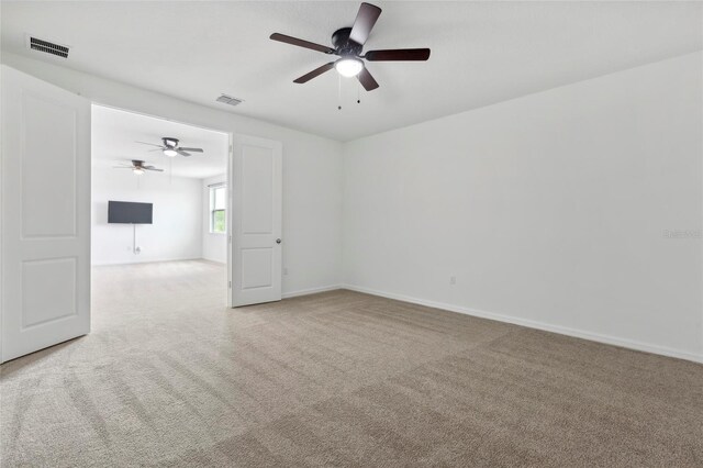 unfurnished room with ceiling fan and light colored carpet