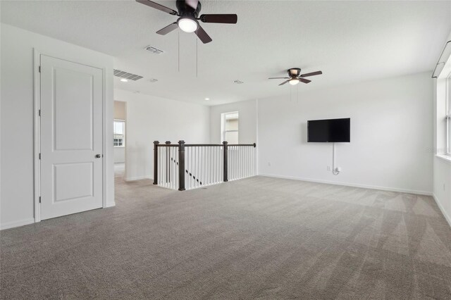 carpeted spare room featuring ceiling fan