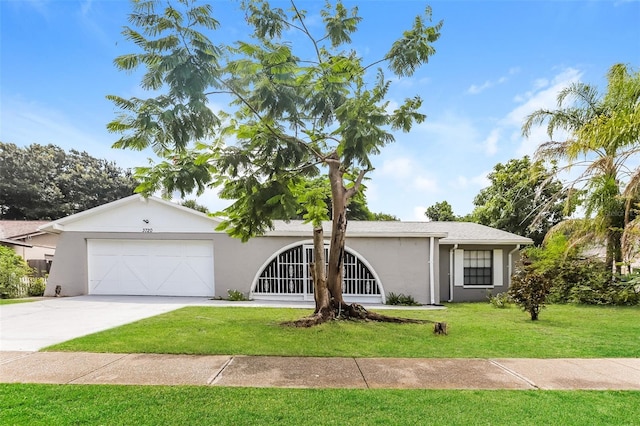 ranch-style house with a garage, driveway, a front yard, and stucco siding