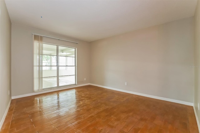 unfurnished room featuring baseboards and wood finished floors