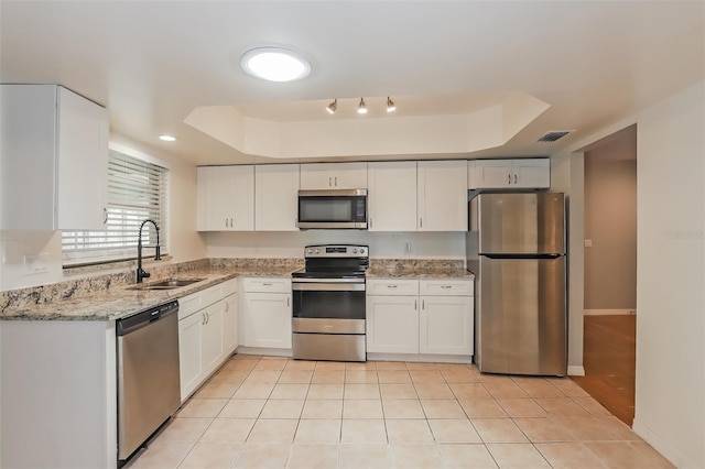 kitchen featuring sink, stainless steel appliances, a raised ceiling, and white cabinets