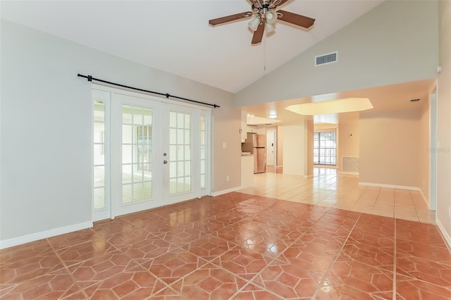 spare room featuring ceiling fan, high vaulted ceiling, a barn door, tile patterned floors, and french doors